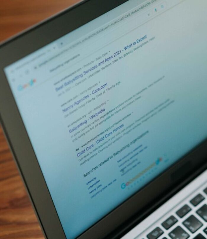 Laptop displaying Google search engine results for babysitting services and apps, representing SEO research and digital marketing analysis.