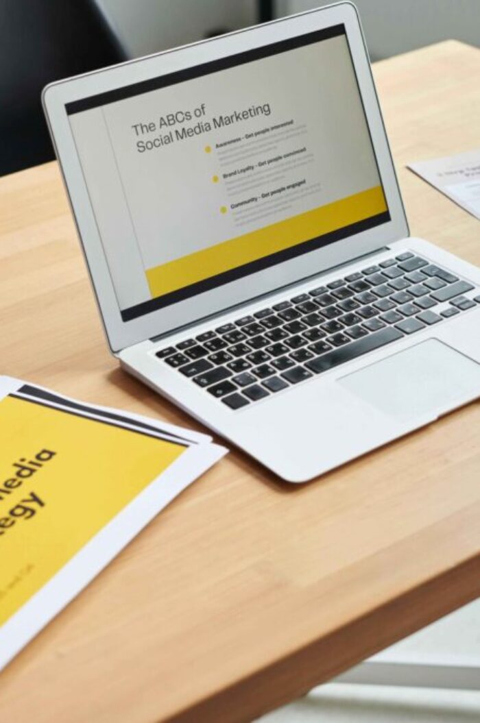 Laptop displaying a social media marketing presentation on a modern workspace desk