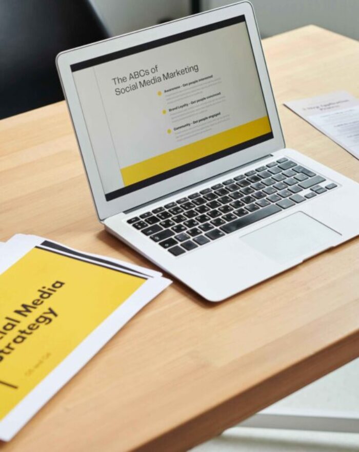 Laptop displaying a social media marketing presentation on a modern workspace desk